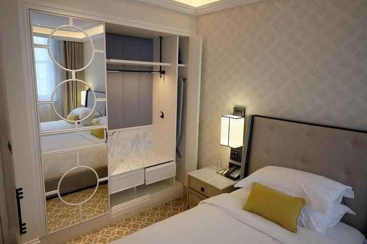 Image de la chambre d'hôtel montrant deux lits et une grande Armoire en fond